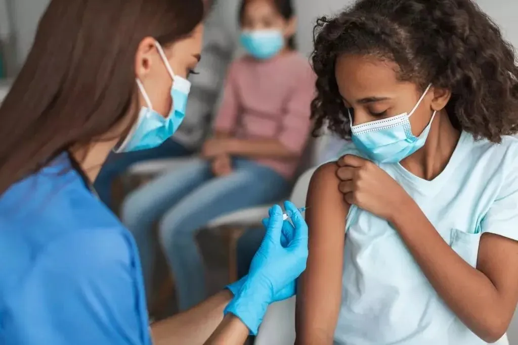 Nurse vaccinating a preteen girl